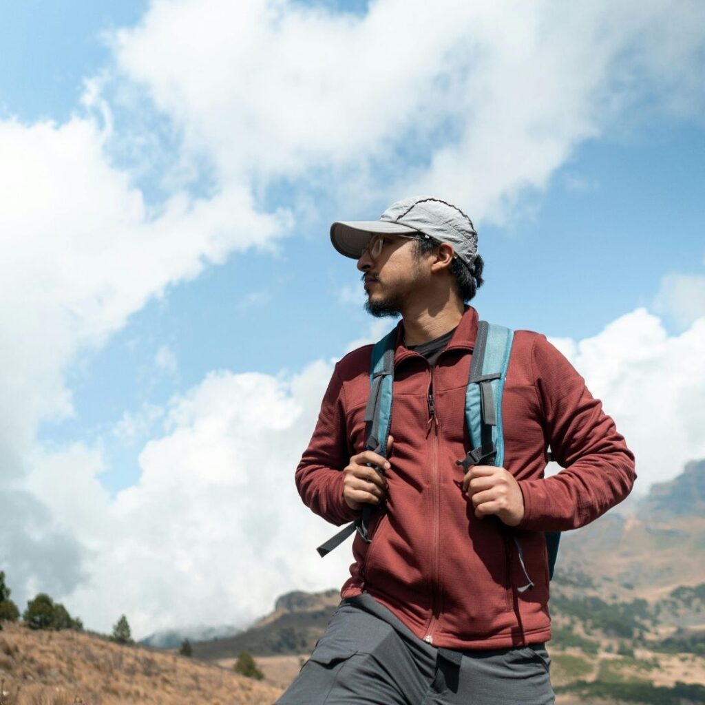 man wearing a backpack looking off into the distance on a hike